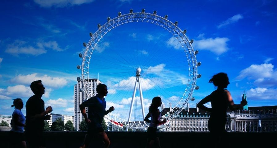Joggers running by Thames, London Eye in background - Michael Betts/Getty Images ©