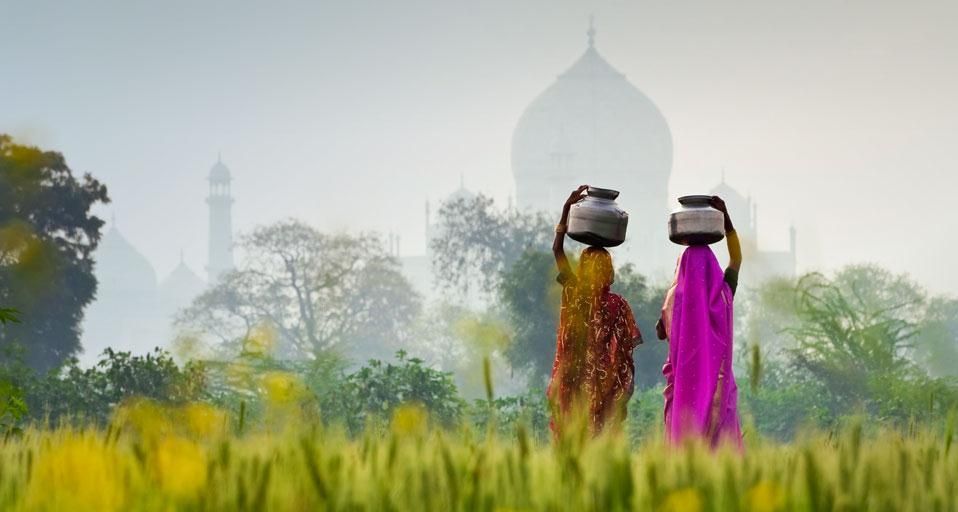 Women carrying water jugs near the Taj Mahal in Agra, India