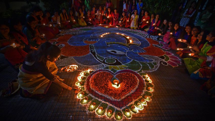 Des étudiants allumant des lampes à huile pour célébrer la fête Diwali à Guwahari, Inde