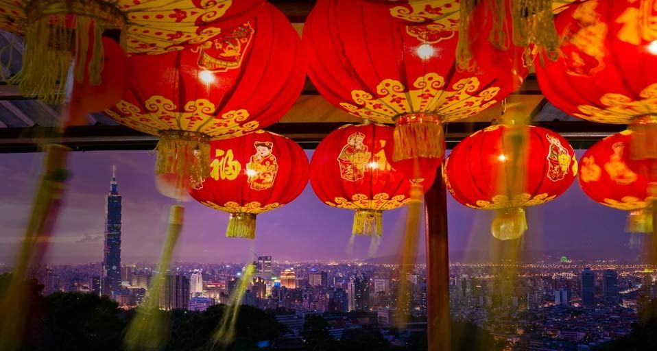 Taipei 101 tower seen in the distance from a temple festooned with paper lanterns in Taipei, Taiwan