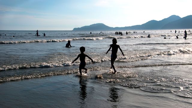 Crianças brincando na praia em Santos, São Paulo