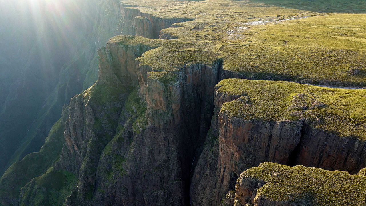 Sunlit grassy highland cliffs