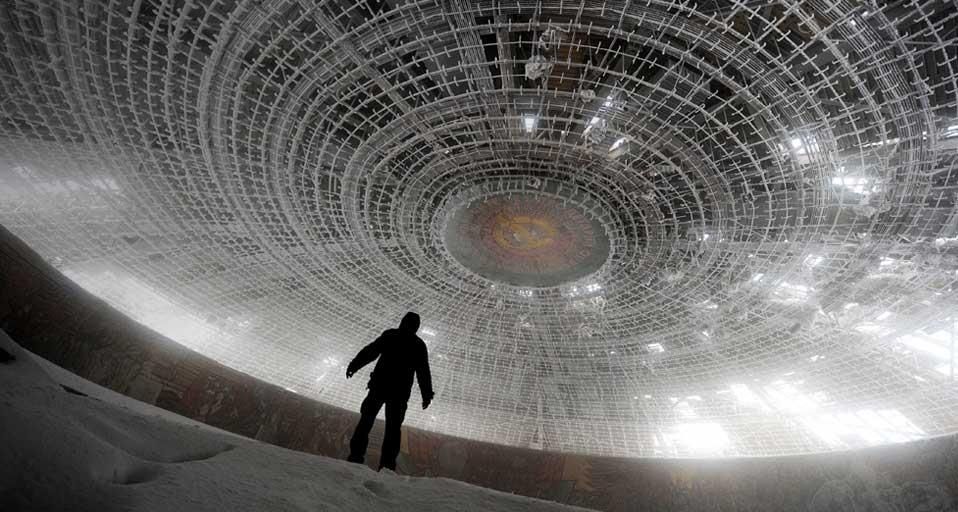 A man walks inside the crumbling skeleton of the House of the Bulgarian Communist Party on Mount Buzludzha, Bulgaria