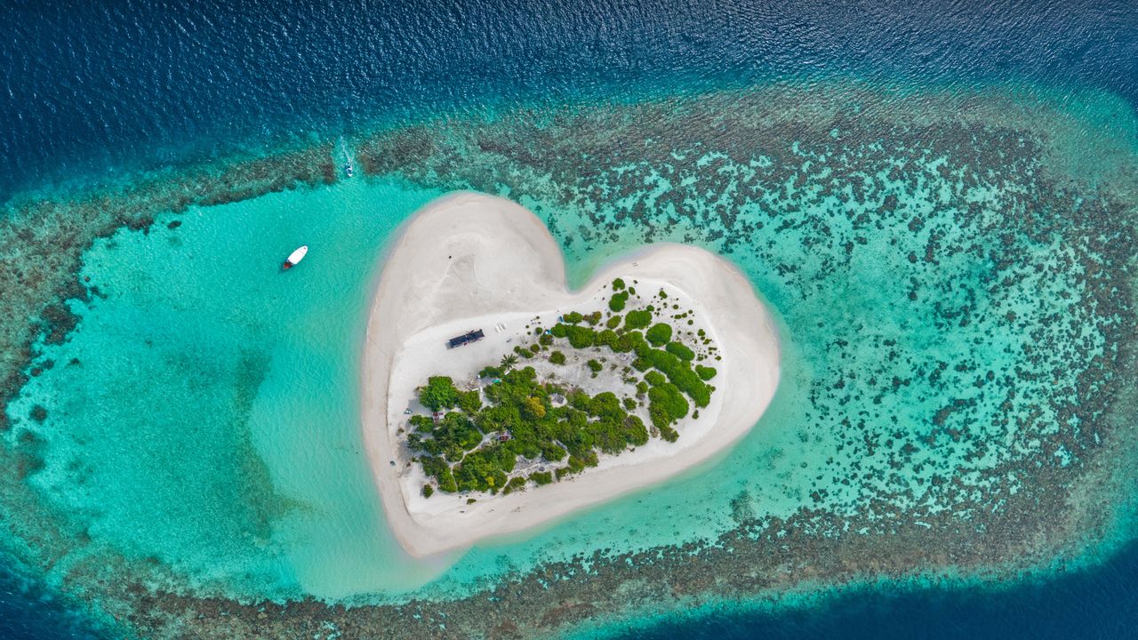 Île en forme de coeur et plage de sable blanc, océan Indien, Maldives