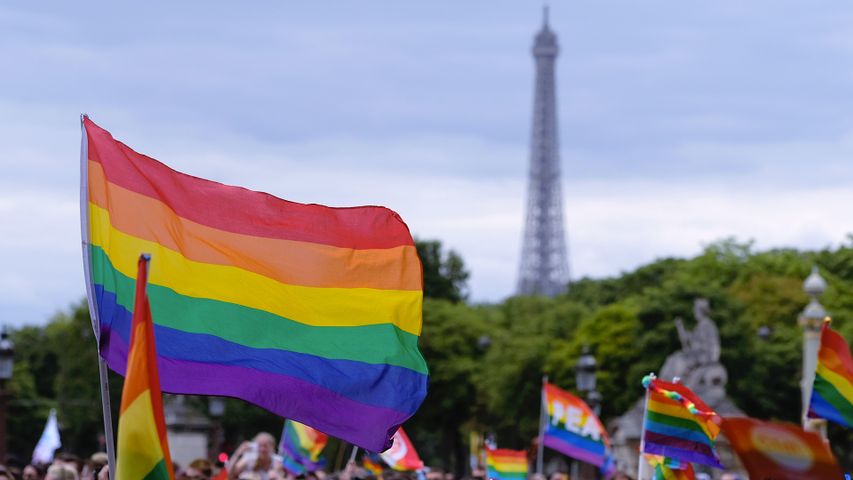 Drapeau arc-en-ciel flottant près de la Tour Eiffel lors de la Marche des fiertés de Paris