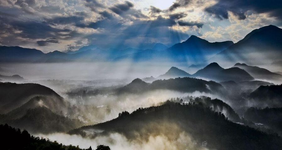 Sun rays slanting into misty valleys in Nantou County, Taiwan