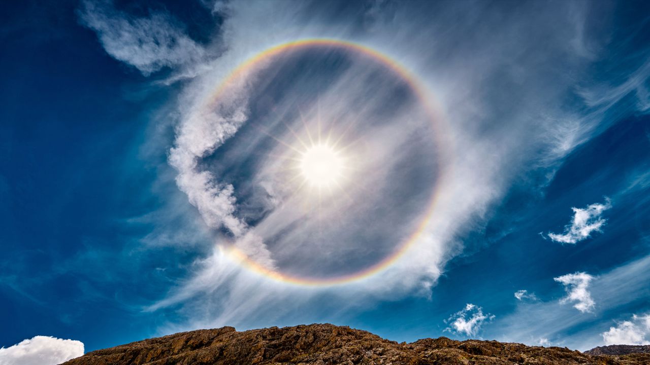 Halo de sol sobre el lago Antermoia en las montañas Dolomitas de Italia