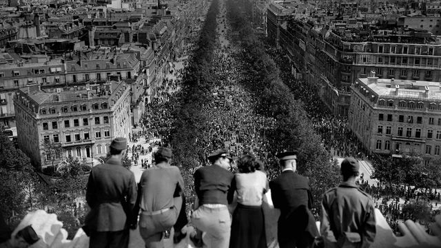 People looking at the crowded Avenue des Champs-Élysées from the Arc de Triomphe on May 8, 1945, Paris, France