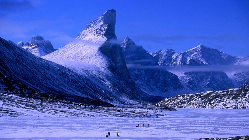 Treeking on frozen Weasel River with Mt Thor at left, Auyuittuq National Park, Baffin Island, Nunavut