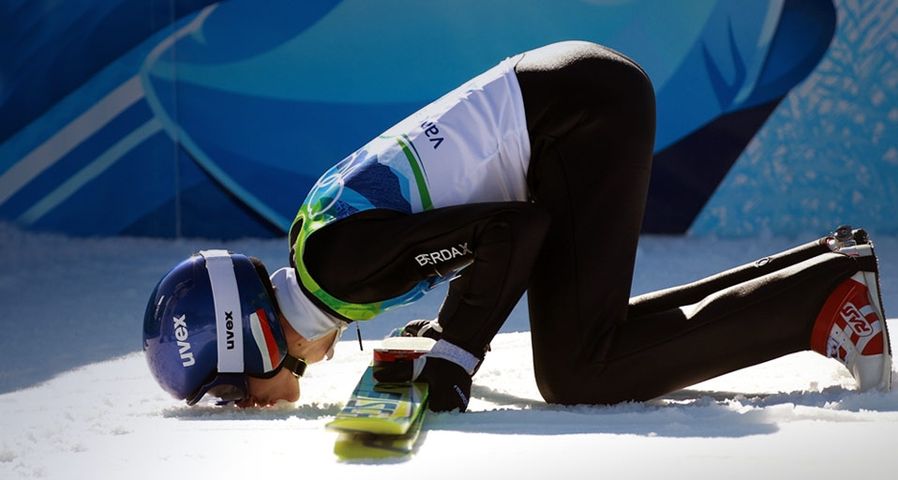 Adam Malysz of Poland kisses the ground after jumping the Large Hill at the 2010 Vancouver Winter Olympics on February 20, 2010