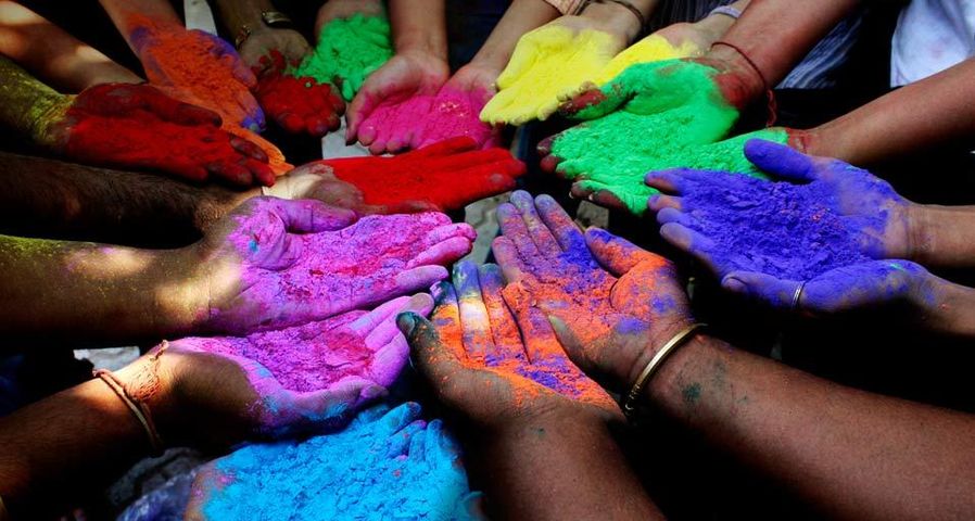 Mains contenant de la poudre colorée de différentes couleurs pour Holî, la fête des couleurs, Ahmedabad, Inde