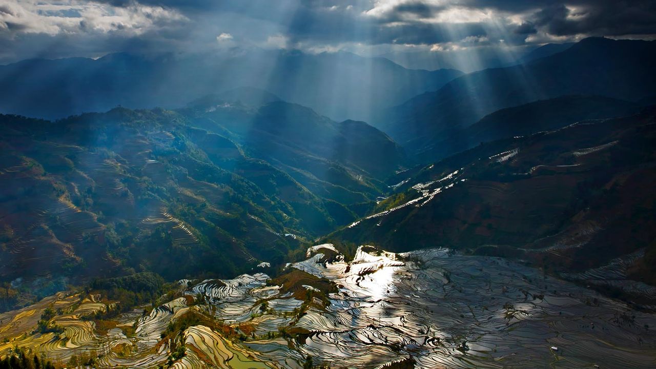 Sunlight reflecting on rice paddy terraces, Yuanyang County, China 