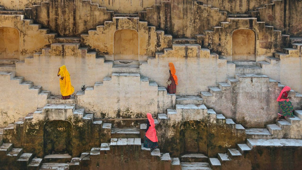 Mujeres ascendiendo por las escaleras de un baori en Jaipur, Rajastán, India