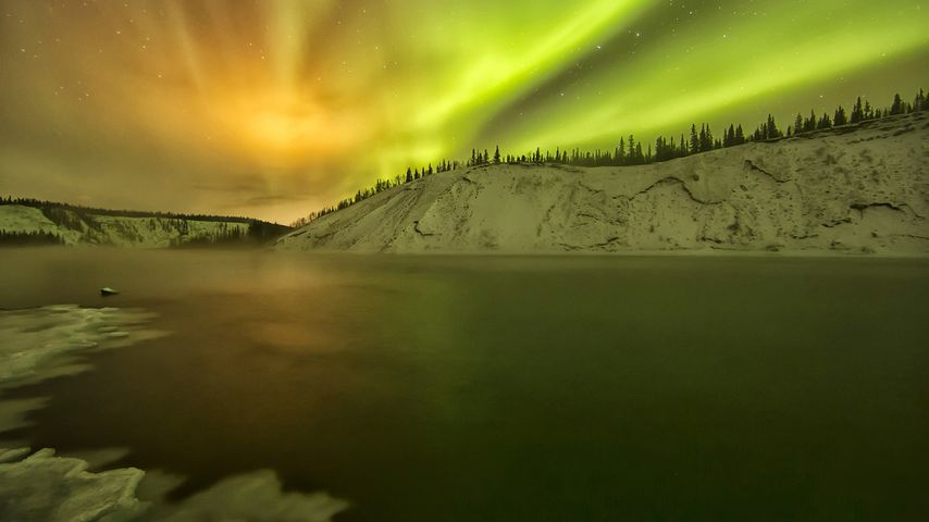 Aurora borealis light up the night sky over the Yukon River in the Yukon