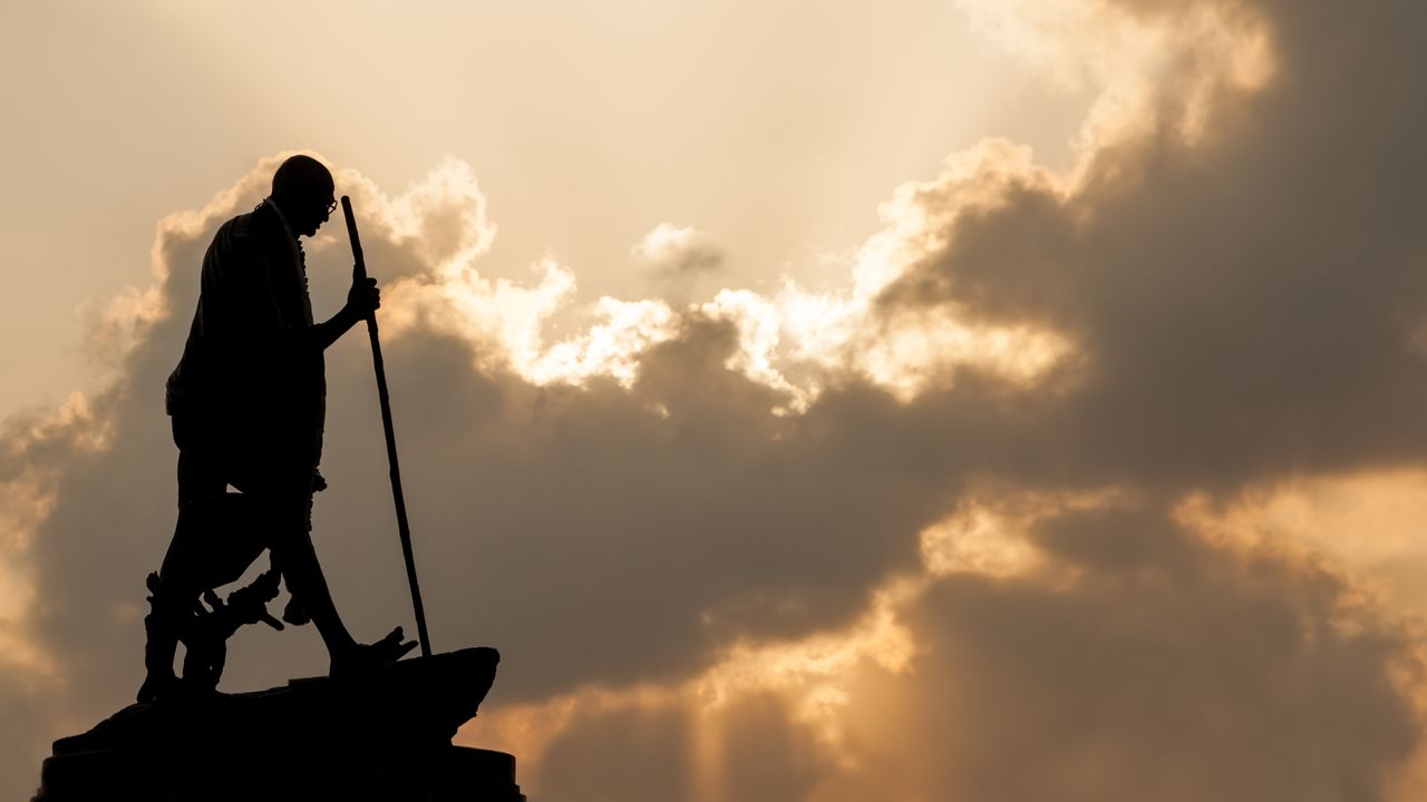 Mahatma Gandhi statue in Chennai at sunset with dramatic sky