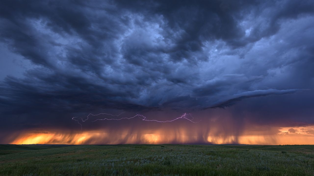 Blitze und Gewitterwolken bei Sonnenuntergang in der Nähe von Bowman, Nebraska, USA