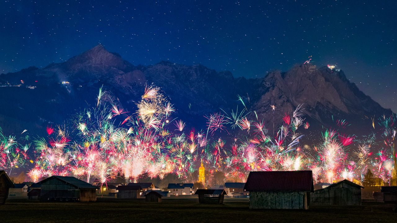Silvesterfeuerwerk über der Stadt Garmisch-Partenkirchen mit Blick auf die Zugspitzgruppe, Bayern