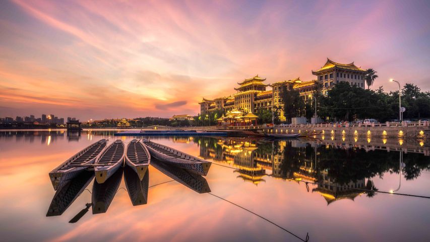 广角镜头下的厦门龙舟池，日落的光洒在传统龙舟上，中国