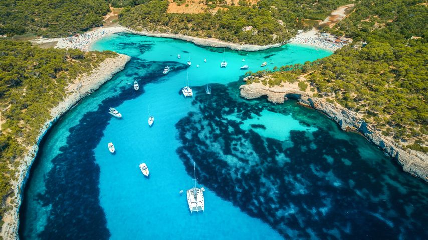 Vista aérea de barcos, yates de lujo y mar transparente en un día soleado en Mallorca, España