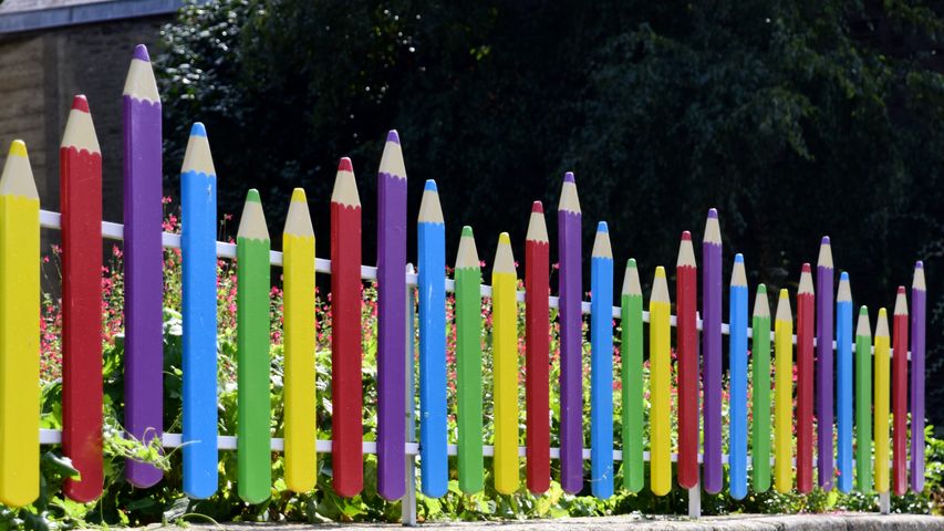 Clôture en bois en forme de crayons de couleur devant une école de Bretagne