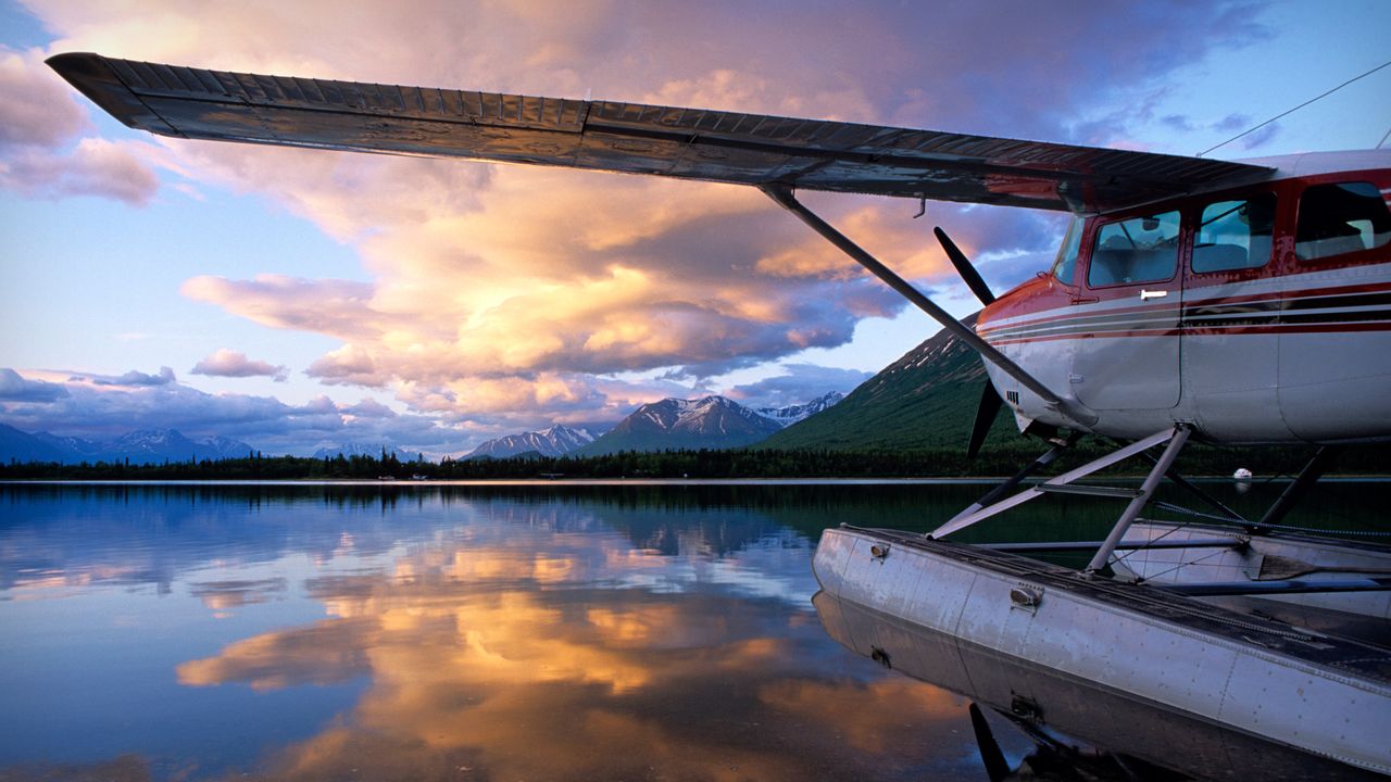 Red and white floatplane mountain lake sunset