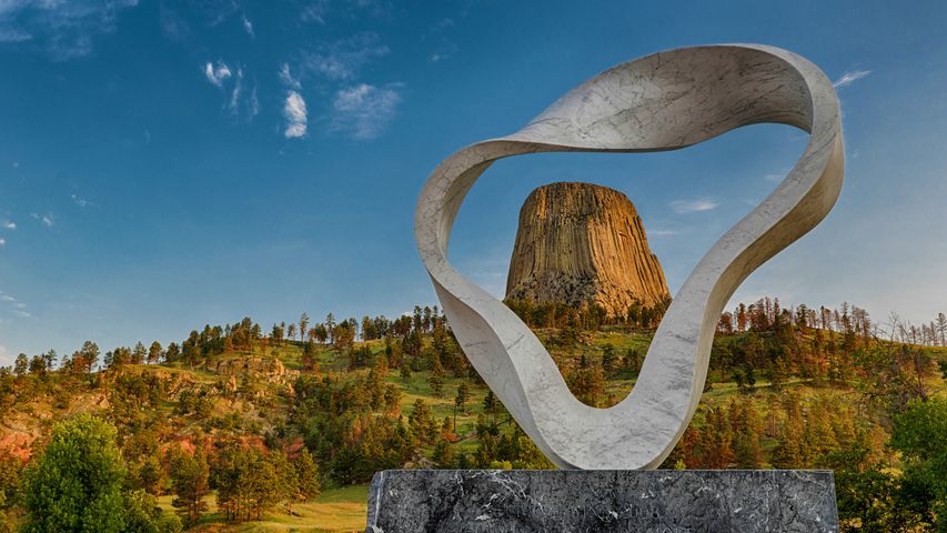 The 'Circle of Sacred Smoke' sculpture by Junkyu Muto frames Devils Tower in Wyoming