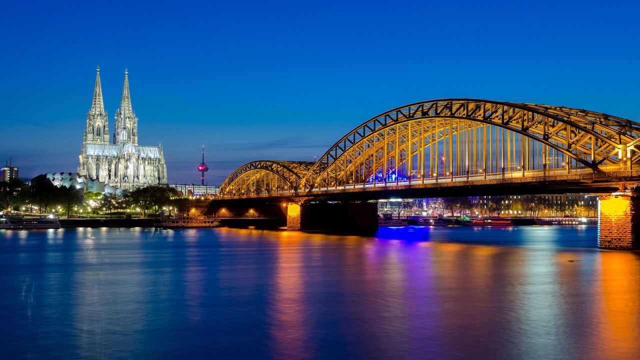 Hohenzollernbrücke mit dem Kölner Dom und dem Rhein bei Sonnenuntergang in Köln